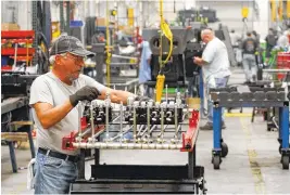  ?? STAFF FILE PHOTO BY DAN HENRY ?? Randy Cook assembles a hydraulic valve set in the large wrecker assembly shop at the Ooltewah plant of Miller Industries Inc.