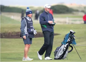  ?? ?? Going the distance Caddie Phil McKenna and Michael Hoey discuss plans at the 14th hole of the final round at the Alfred Dunhill Links Championsh­ip