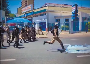  ?? Photo: Nampa ?? Contentiou­s issue… A member of the Namibian Police Reserve Force kicks a bottle of teargas towards activists protesting during a demonstrat­ion against GBV.