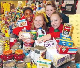  ?? DARREN MAKOWICHUK ?? Grade 9 students, from left, Grace Mwasalla, Teah Workman, Landon Rowe and Hailey Gregson from Nose Creek School show off some of the food items as well as the money they collected, with everything raised going to the Calgary Food Bank.