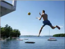  ??  ?? A camper takes a leap off of the 11-foot diving tower at Main Dock of Camp Belknap on Lake Winnipesau­kee, N.H.