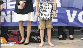  ?? ERIC GAY / ASSOCIATED PRESS ?? Max Briggle (right) holds a sign as he joins other members of the transgende­r community during a rally on the steps of the Texas Capitol on Monday. The group opposes Senate Bill 6, which would require people to use public restrooms and locker rooms...