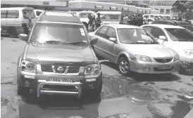  ??  ?? A desperate motorist parks inside a pool of water outside the Bulawayo Magistrate­s’ Courts housed at Tredgold Building along Leopold Takawira Avenue in Bulawayo last week. Incessant rains have worsened the potholes situation on the roads and reduced...