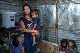  ?? Photograph: Nadège Mazars/Guardian ?? Elaine Rojas, 27, and her four children in the shack in La Pista where they live with her husband and 2,000 other Venezuelan families. The pale hair of Kevin, her youngest child, is a sign of malnutriti­on.