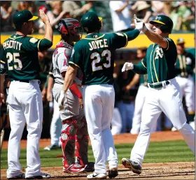  ?? KARL MONDON/TRIBUNE NEWS SERVICE ?? The Oakland Athletics' Matt Chapman (26) is greeted at home plate by Scott Piscotty (25) and Matt Joyce (23) after hitting a three-run homer off Shohei Ohtani of the Los Angeles Angels on April 1 in Oakland.