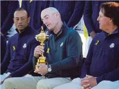  ??  ?? FURYK memegang Piala Ryder sambil dilihat Woods (kiri) dan Mickelson pada sesi foto.