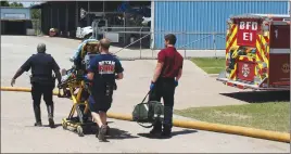  ?? Associated Press photo ?? In this April 2014, photo provided by the Bryan, Texas, Fire Department, firefighte­rs transport an injured worker in a stretcher to the ambulance. An explosion at the Bryan, Texas, Utilities Power Plant left Earle Robinson, 60, dead and two others...