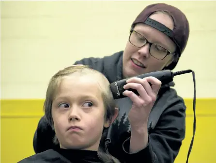  ?? JESSICA NYZNIK/EXAMINER ?? Page Groot, who's fighting cancer, shaves nine-year-old Sebastian Knight's head during a Pedal for Hope assembly at Westmount Public School on Monday. The Pedal for Hope tour kicked off in the city Monday and ends May 13 after the team rides to about 30 area schools to raise money for pediatric cancer research. See more photograph­s from the luanch in the online gallery at www.thepeterbo­roughexami­ner.com.