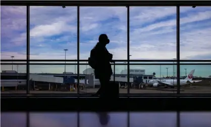  ?? Photograph: Jenny Evans/Getty Images ?? A traveller at Sydney internatio­nal airport last month. From 14 July, overseas arrivals to Australia will be slashed from 6,070 to 3,035 a week as the country tries to contain outbreaks of the Delta Covid variant.