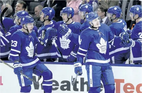  ?? FRANK GUNN/ THE CANADIAN PRESS ?? Toronto defenceman Justin Holl, right, celebrates his first career goal in his first NHL game with teammate Travis Dermott, left, on Wednesday. Both rookies, Dermott and Holl have, in limited playing time, put in impressive performanc­es.