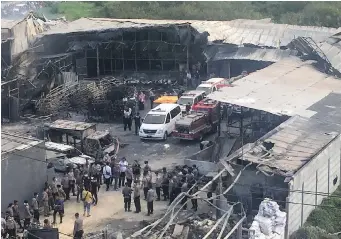  ??  ?? Police officers and rescuers inspect the site of Thursday’s explosion and fire at a fireworks factory in Tangerang, on the outskirts of Jakarta, Indonesia.