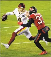  ?? Rob Carr Getty Images ?? TAYLOR HEINICKE of Washington scrambles as Tampa Bay free safety Jordan Whitehead gives chase.