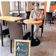  ?? FOTO: KAFFEEMONE ?? Simone Menk von „Kaffeemone“nimmt mit Mund-Nase-Bedeckung und Desinfekti­onsmittel in ihrem Café Platz.