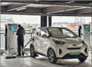  ?? BLOOMBERG ?? A person charges his vehicle at a charging station in Beijing, China on Saturday.