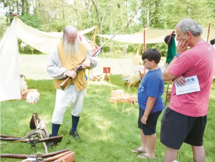  ?? AMY SHORTELL/THE MORNING CALL ?? Harry Bunham of Delaware teaches spectators about guns used during the Revolution­ary period during the Jacobsburg Historical Society’s American Revolution­ary War Living History Weekend in 2021 in Bushkill Township.