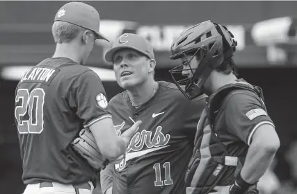  ?? KEN RUINARD/STAFF ?? Clemson pitching coach Jimmy Belanger talks with senior relief pitcher Nick Clayton during a game earlier this season.