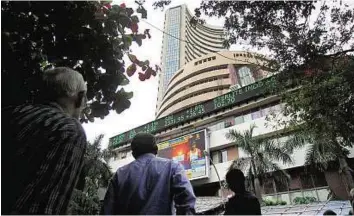  ?? PTI ?? Unsupporti­ve equities Investors outside the Bombay Stock Exchange watch the Sensex on the digital display.