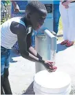  ??  ?? SERVICIO. Un niño de la aldea San Juan prueba el agua.