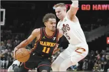  ?? AP photo ?? The Hawks’ Trae Young drives past Cavaliers guard Sam Merrill in the first half of Atlanta’s loss to Cleveland on Saturday.
n