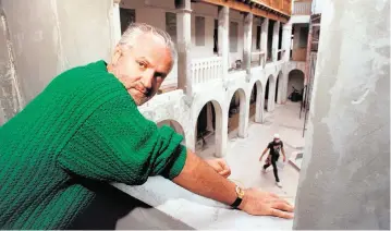  ?? MARICE COHN BAND Miami Herald file ?? In this file photo from March 16, 1993, designer Gianni Versace looks out from a second story window overlookin­g his patio during renovation of his Casa Causarina mansion on Ocean Drive. Four years later, on July 15, 1997, Versace would be shot to death on his front steps by serial killer Andrew Cunanan.