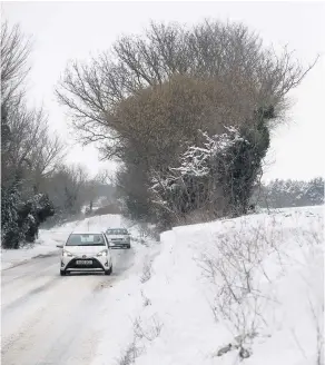  ??  ?? Cars make their way along a snow covered road in Barham near Ipswich. See Question 1