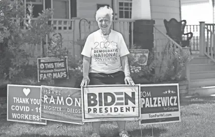  ?? MICHAEL SEARS / MILWAUKEE JOURNAL SENTINEL ?? Dawn Martin of West Allis, a longtime Democrat, will likely be a volunteer at the DNC in Milwaukee. She is shown here at her home with yard signs supporting Democrats running for office.