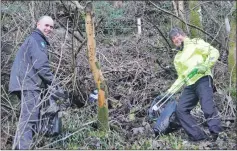  ??  ?? Adrian Beard and Frankie Lanos brave the muddy bank at the back of Atlantis Leisure Centre to clear rubbish.