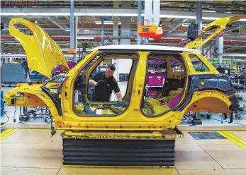  ?? FOTO: AFP ?? Mini-Produktion in Oxford, der ältesten Autofabrik der Welt: Die Autoindust­rie ist hochvernet­zt, nationale Wertschöpf­ungsketten spielen schon lange keine Rolle mehr. So werden die in Oxford gebauten Minis von BMW mit Motoren aus Österreich bestückt, in...