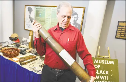  ?? Hearst Connecticu­t Media file photo ?? Bruce Bird shows a German 88mm shell that is a small part of the collection he presents at Norwalk City Hall as founder and curator of the Museum of Black WW II History on April 11, 2018. Bird is trying to relocate the museum from Pownal, Vt., to Stamford and spent the day at city hall showing people some of the items he has collected.