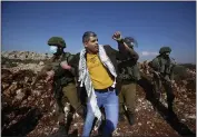  ?? MAJDI MOHAMMED — THE ASSOCIATED PRESS ?? Israeli soldiers arrest a Palestinia­n during a protest against the expansion of Jewish settlement­s near the West Bank town of Salfit, on Monday.