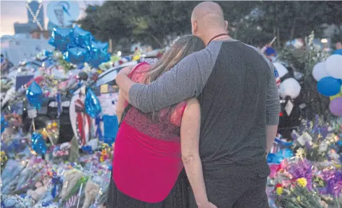  ?? AFP ?? A couple embraces as they stand outside Dallas Police Headquarte­rs at the memorial for officers killed in the recent sniper attack in Dallas, Texas, on Saturday. The gunman behind a sniper-style attack was an army veteran and loner driven to exact...