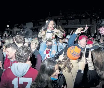  ?? Charity Rachelle, © The New York Times Co. ?? Alabama fans crowd onto The Strip, forming a massive celebrator­y mob in Tuscaloosa, Ala., after the Crimson Tide won the National Championsh­ip on Monday night.