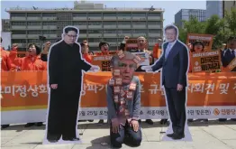  ?? — AP ?? A protester wearing a mask of US President Donald Trump performs with cut- out photos of North Korean leader Kim Jong- un and South Korean President Moon Jae- in during a rally against the United States' policies against North Korea near the US embassy...