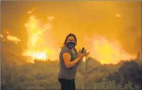  ?? RINGO H.W. CHIU — THE ASSOCIATED PRESS ?? A woman watches as the Bobcat Fire burns in Juniper Hill Friday, Sept. 18.