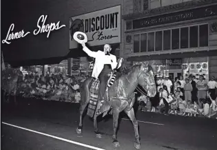  ?? BARNEY SELLERS / THE COMMERCIAL APPEAL FILE ?? LEFT: Mayor William B. Ingram Jr. rides through Downtown Memphis on May 18, 1964, as he led the Grand Parade, hat in hand and pipe in mouth, to wind up the five-day Cotton Carnival.