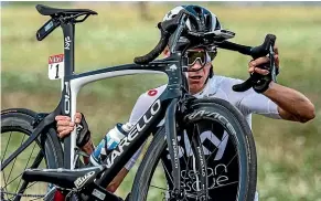  ?? AP ?? Chris Froome carries his bike to the road after crashing into a ditch on the opening stage of the Tour de France.