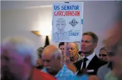  ??  ?? Daniel Goodman of Albuquerqu­e holds a sign Tuesday in support of Gary Johnson as the Libertaria­n tells supporters at Hotel Albuquerqu­e he’s running for a U.S. Senate seat.