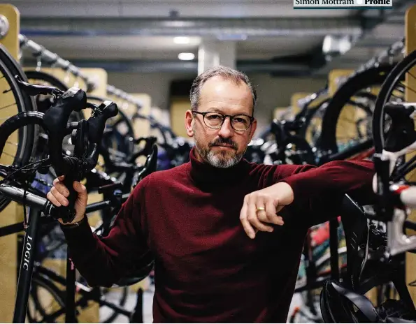  ??  ?? Simon Mottram stands by the bike racks used by the staff at Rapha HQ. ‘As riders ourselves there are a lot of things that Rapha tries to do to make our riding lives better,’ he says