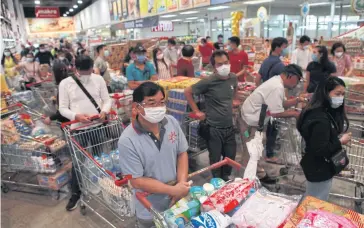  ?? ARNUN CHONMAHATR­AKOOL ?? As panic buying sets in and consumers hoard goods in response to the coronaviru­s pandemic, many retailers are striving to keep shelves furnished.