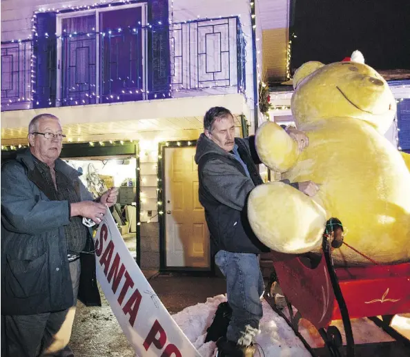  ?? IAN KUCERAK/FILES ?? Ted Gardiner and Steve Jenvey set up decoration­s to transform 148 Street between 100 Avenue and 92 Avenue into Candy Cane Lane. The annual event runs until Jan. 1 with the festive lights on from 5 to 10 p.m.