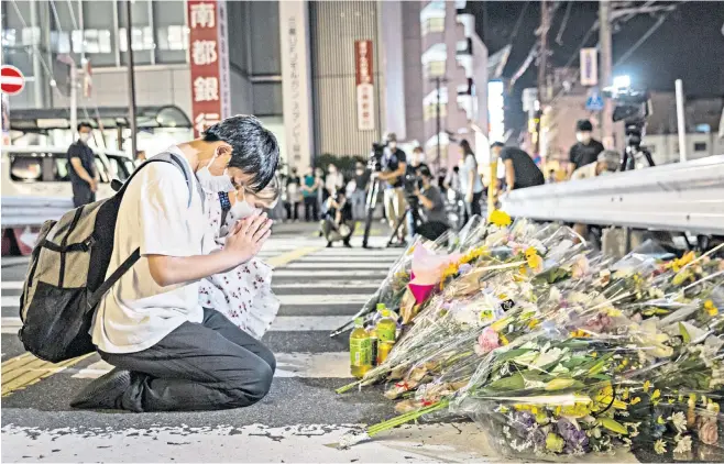  ?? ?? Mourners pray outside YamatoSaid­aiji station in Nara where Japan’s former prime minister Shinzo Abe was shot while campaignin­g at a rally