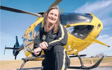  ?? STEVE HELBER/AP ?? Air ambulance flight paramedic Rita Krenz poses in front of her company’s helicopter in Weyers Cave, Virginia. Krenz started a fundraisin­g campaign that brought in more than $18,000 that has helped RIP Medical Debt forgive the debt of more than 900 people.