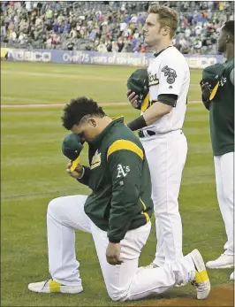  ?? ERIC RISBERG — ASSOCIATED PRESS ?? A’s catcher Bruce Maxwell, left, kneels as teammate Mark Canha, right, looks on during the national anthem before the start of Saturday night’s game against the Rangers.