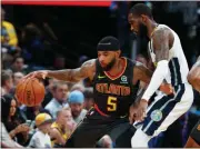  ?? David Zalubowski / AP ?? Atlanta’s Malcolm Delaney (left) works the ball inside as Denver’s Will Barton defends. The Hawks won 110-97.