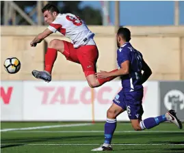  ??  ?? Balzan's Montenegri­n striker Bojan Kaljevic (L) just misses the target, reaching first ahead of Matthew Gauci of St. Andrews. Photo: Domenic Aquilina