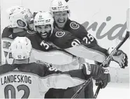  ?? John Bazemore/Associated Press ?? Avalanche center Nazem Kadri (91) is congratula­ted by teammates after his overtime goal.