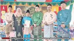  ??  ?? TAHNIAH: Awang Zainuri menyampaik­an sijil khatam al-Quran kepada Hafizhan Hamzah.