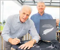  ?? Photo / Cathy Asplin ?? Former All Black Stan Meads adds his signature to his brother’s, the late Colin Meads, on a limited edition jersey, won in the auction by Clayton Timmo.