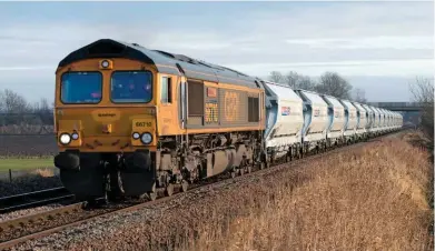  ?? PETER FOSTER. ?? GB Railfreigh­t 66710 Phil Packer BRIT passes Tufts Crossing (west of March) on December 19 2017, with a rake of brand new IIA sand hoppers on a Middleton Towers-Goole sand train. There has been a rise in the amount of rail freight carried, with...