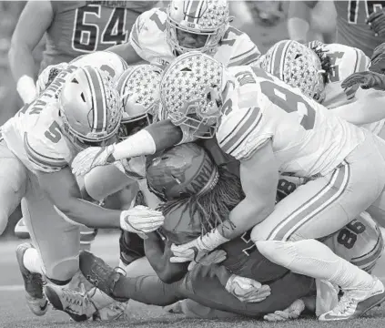  ?? PATRICK SMITH/GETTY IMAGES ?? Maryland running back Kenneth Goins Jr. (Gilman) disappears under a pile of Ohio State defenders in the second quarter.